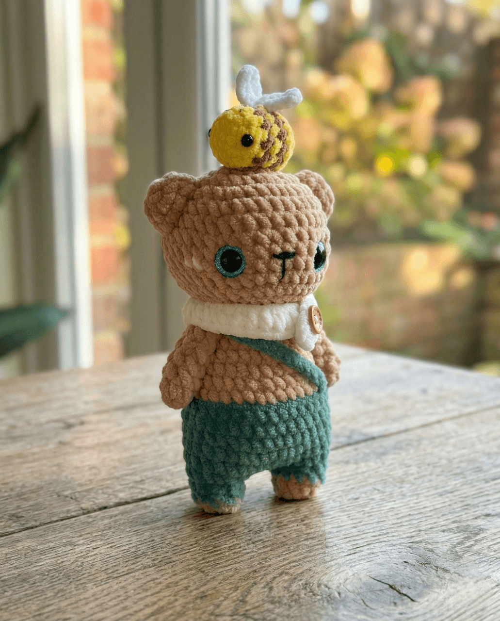 Crochet amigurumi bear in brown yarn with a friendly face