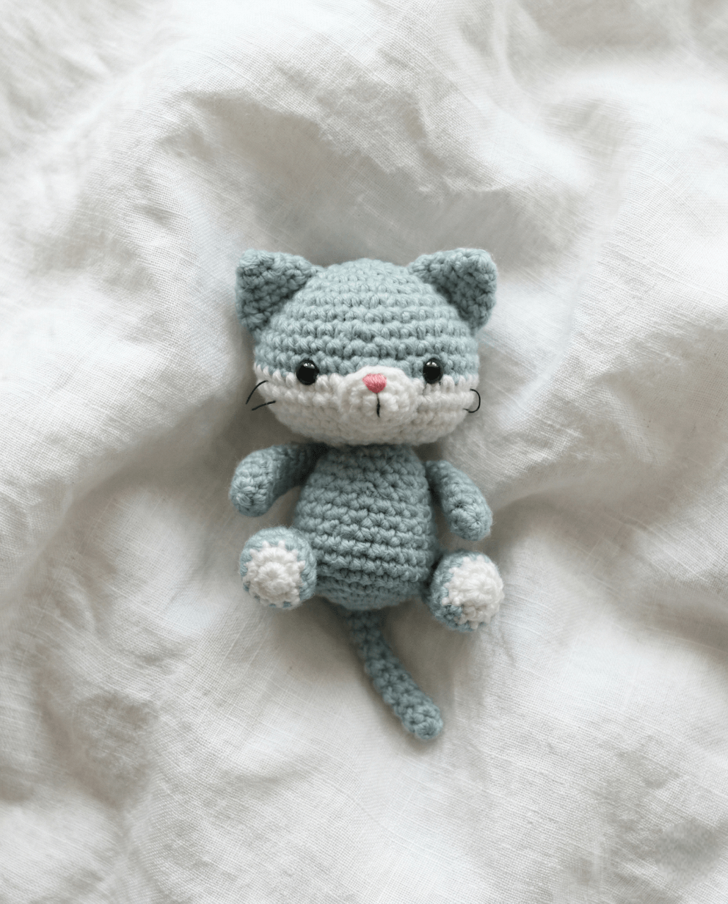 Small crochet amigurumi cat with whiskers and a sweet face