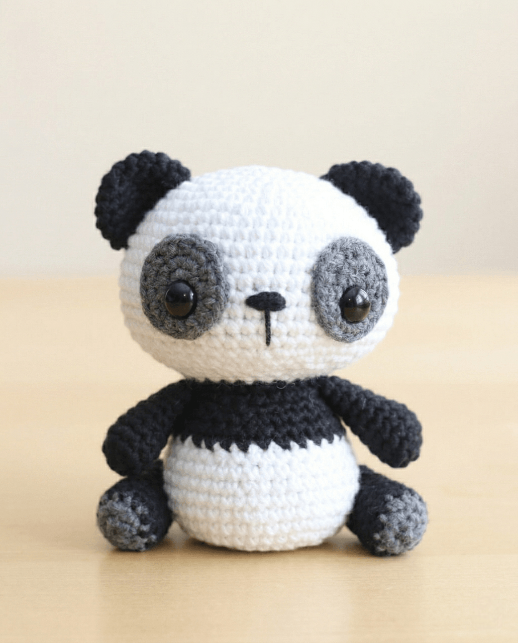 Crochet amigurumi panda in black and white yarn