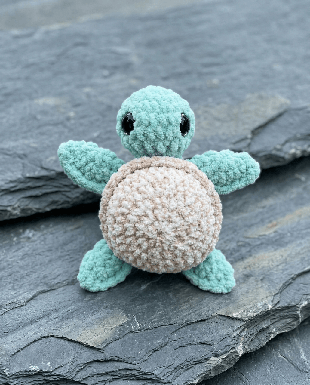 Crochet amigurumi turtle with a colorful shell and smiling face