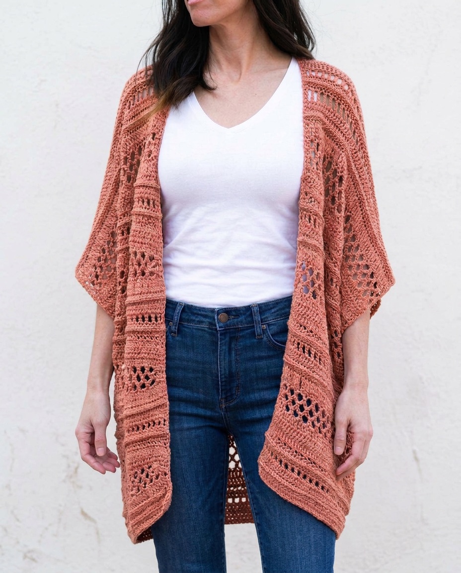 Terracotta crochet wrap with airy openwork panels worn open like a kimono over a white top and jeans