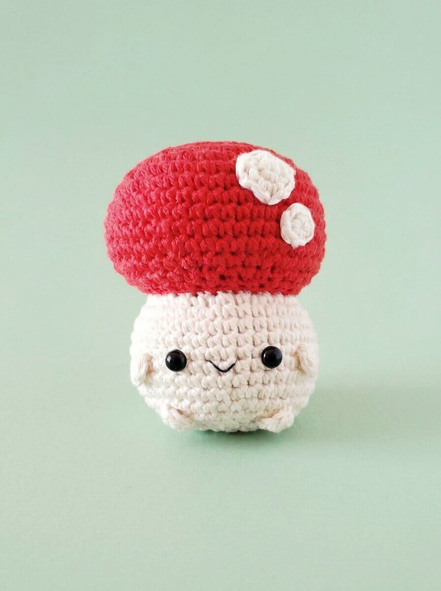Kawaii crochet mushroom amigurumi with a red spotted cap and chubby white body