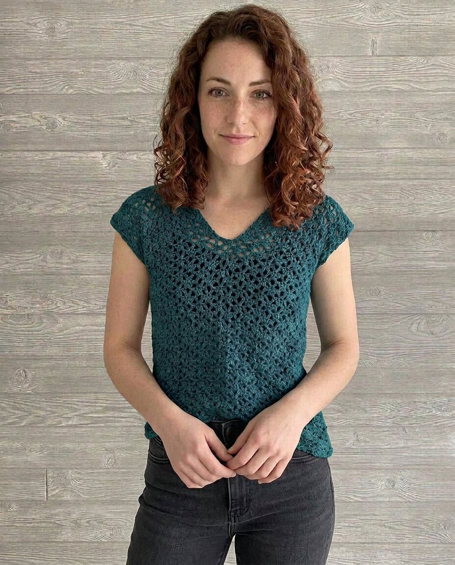 Teal crochet top with a V-neck, cap sleeves, and an airy V-stitch lace pattern worked throughout the body